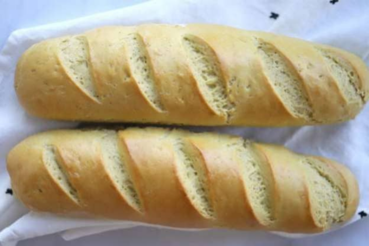 Einkorn French bread, two scored baguette loaves cooling on a cloth