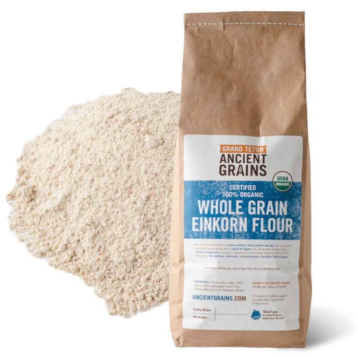 Brown bag of Grand Teton Ancient Grains Organic Whole Grain Einkorn Flour next to a pile of flour.